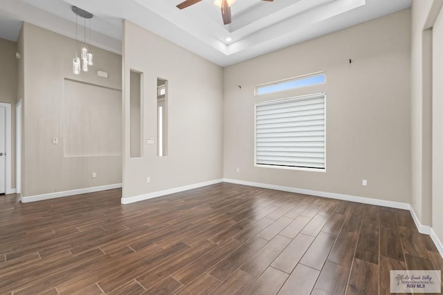 9372 Fan Palm Dr, Los Fresnos, TX 78521 - spare room with a raised ceiling, a ceiling fan, dark wood-style floors, and baseboards