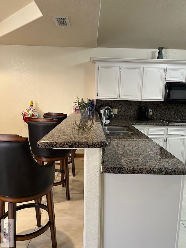 4870 Mckenzie Rd, Brownsville, TX 78521 - kitchen featuring a sink, black appliances, white cabinets, and a peninsula
