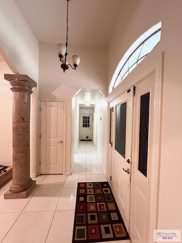 4870 Mckenzie Rd, Brownsville, TX 78521 - corridor featuring a chandelier, light tile patterned floors, decorative columns, and a high ceiling
