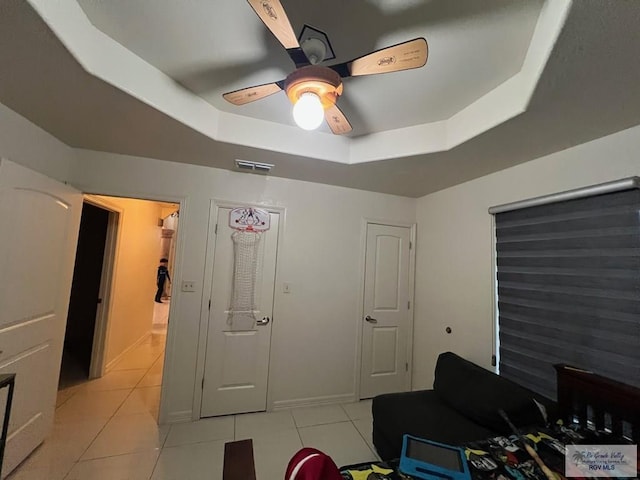 4870 Mckenzie Rd, Brownsville, TX 78521 - bedroom with a raised ceiling, light tile patterned flooring, and a ceiling fan