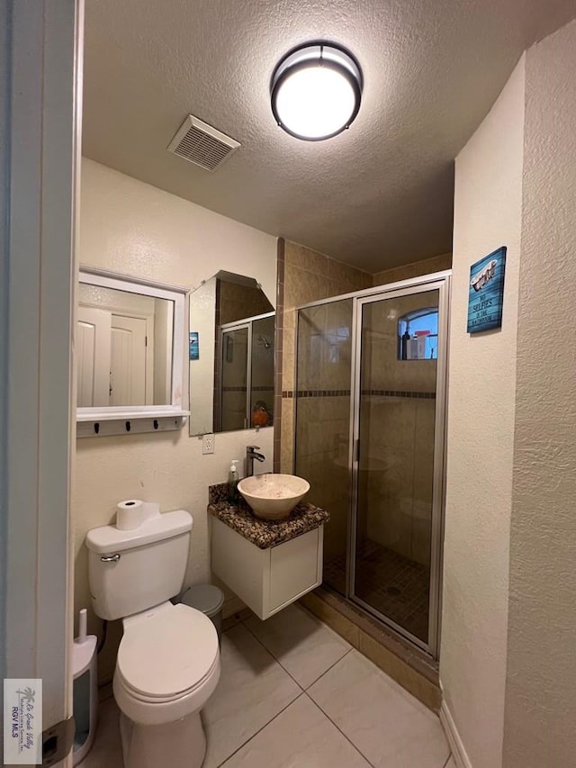 4870 Mckenzie Rd, Brownsville, TX 78521 - bathroom with a textured ceiling, toilet, vanity, a shower stall, and tile patterned floors