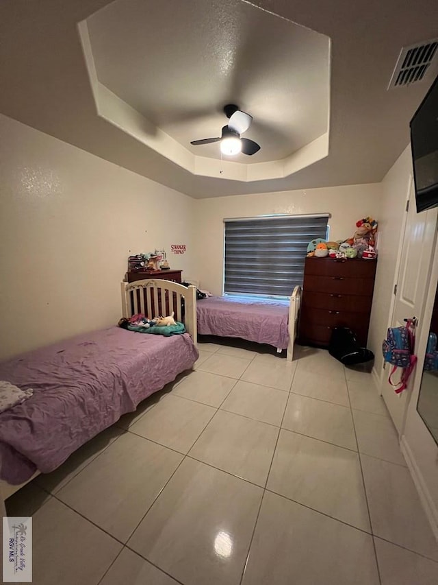 4870 Mckenzie Rd, Brownsville, TX 78521 - bedroom featuring a tray ceiling, light tile patterned floors, and a ceiling fan