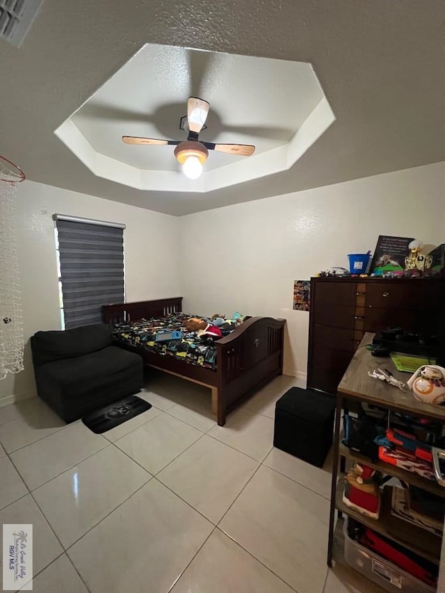 4870 Mckenzie Rd, Brownsville, TX 78521 - bedroom featuring a tray ceiling, tile patterned floors, ceiling fan, and baseboards