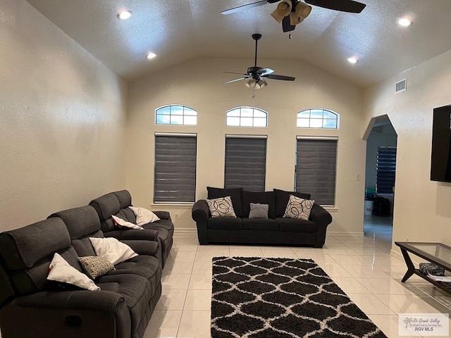 4870 Mckenzie Rd, Brownsville, TX 78521 - living room featuring ceiling fan, vaulted ceiling, light tile patterned floors, arched walkways, and a textured ceiling