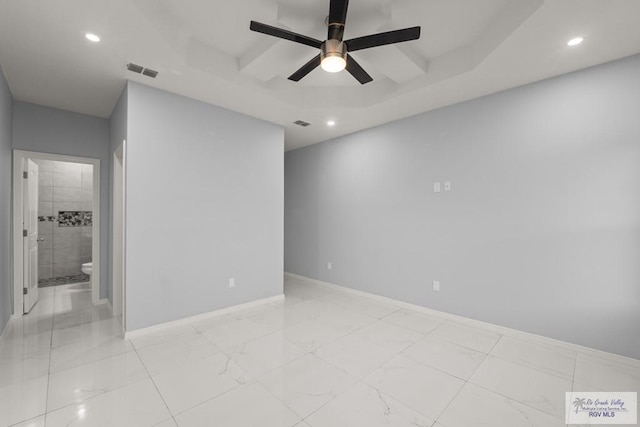 unfurnished room with visible vents, recessed lighting, a tray ceiling, and baseboards