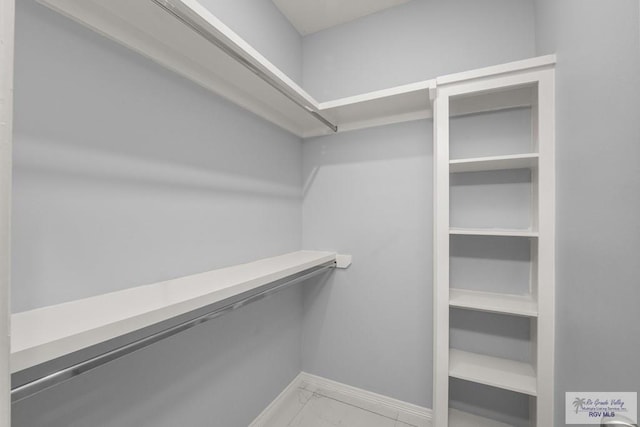 spacious closet with marble finish floor