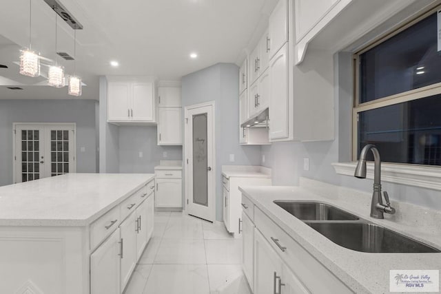 kitchen featuring french doors, hanging light fixtures, marble finish floor, white cabinetry, and a sink