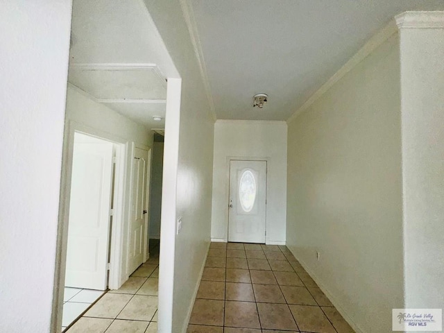 foyer with light tile patterned floors and crown molding