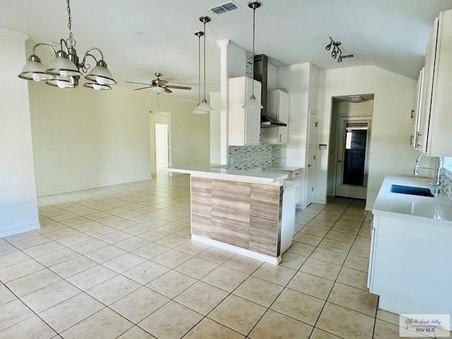 kitchen featuring vaulted ceiling, white cabinetry, sink, and ceiling fan with notable chandelier