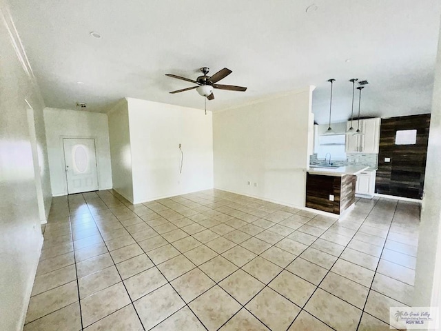 interior space featuring white cabinetry, sink, ceiling fan, pendant lighting, and light tile patterned floors