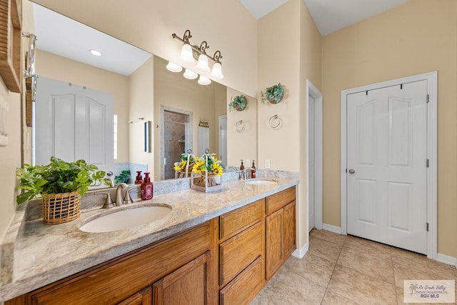 full bath with tile patterned flooring, a sink, a shower stall, and double vanity