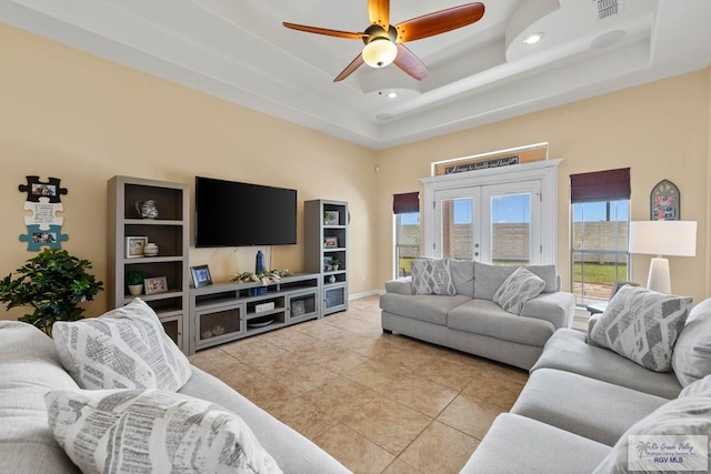 living room featuring light tile patterned floors, visible vents, a raised ceiling, ceiling fan, and recessed lighting