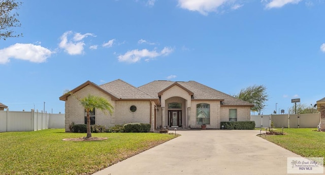 french country home featuring a front yard, fence, and a gate