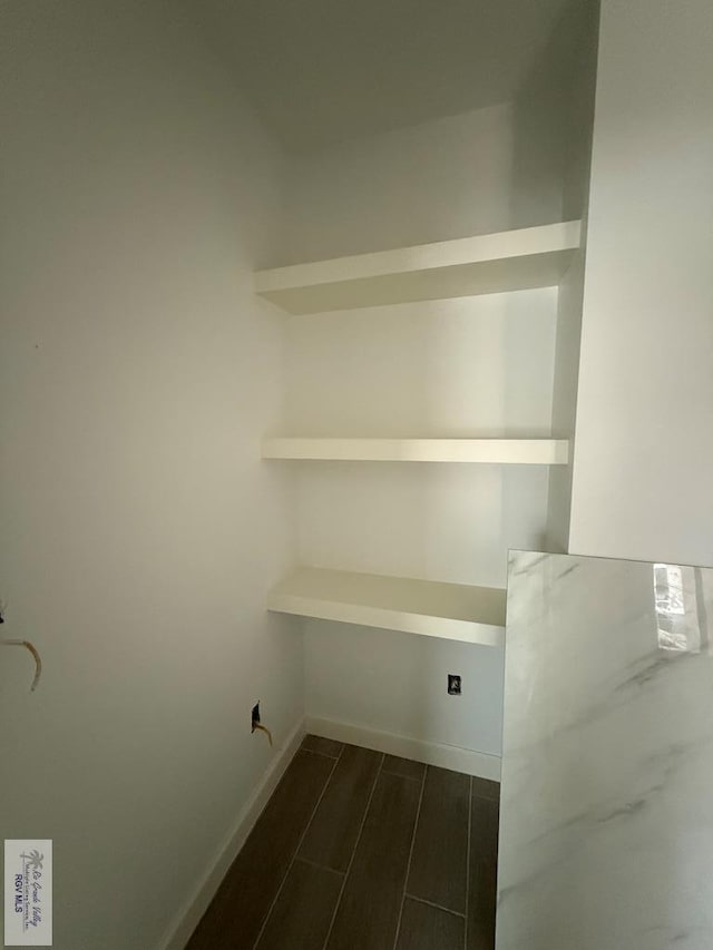 clothes washing area with wood tiled floor and baseboards