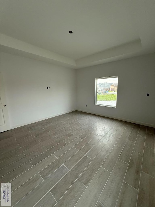 unfurnished room with baseboards and wood tiled floor