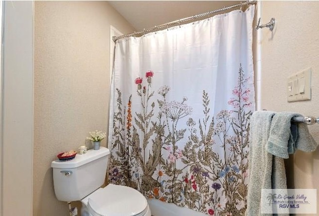 bathroom featuring shower / bath combo with shower curtain and toilet