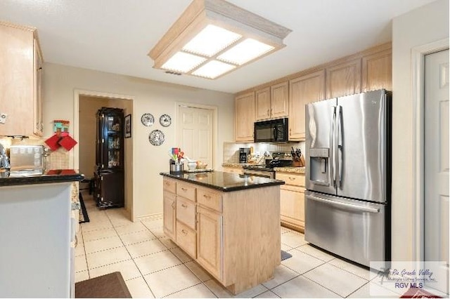 kitchen with tasteful backsplash, appliances with stainless steel finishes, light brown cabinets, and a kitchen island