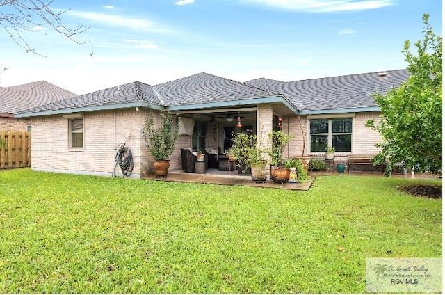 back of property with a patio area and a yard