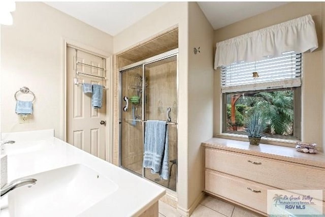 bathroom with an enclosed shower, vanity, and tile patterned flooring