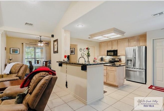 kitchen with light tile patterned floors, kitchen peninsula, light brown cabinetry, and stainless steel appliances