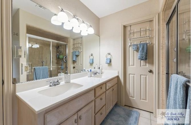 bathroom with tile patterned floors, a shower with door, and vanity