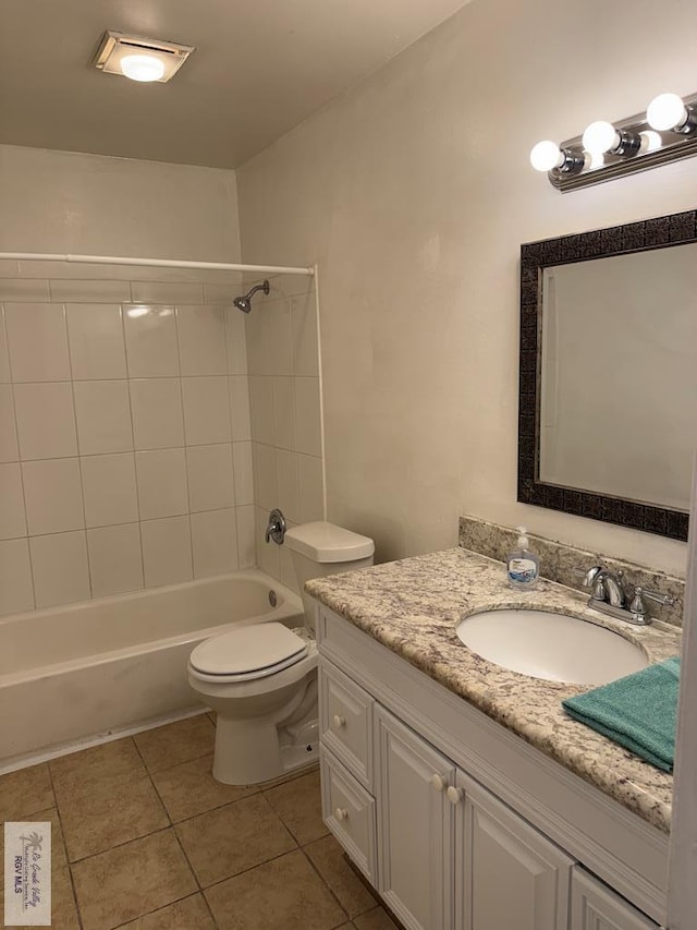 full bathroom featuring toilet, tile patterned floors, vanity, and tiled shower / bath combo