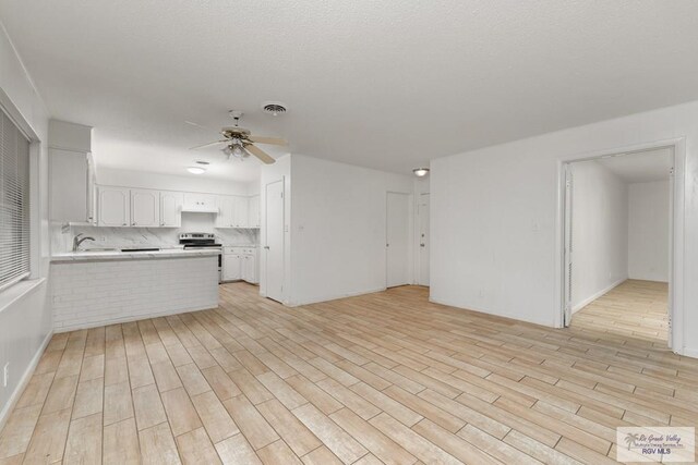 kitchen featuring white cabinets, ceiling fan, light hardwood / wood-style floors, and kitchen peninsula