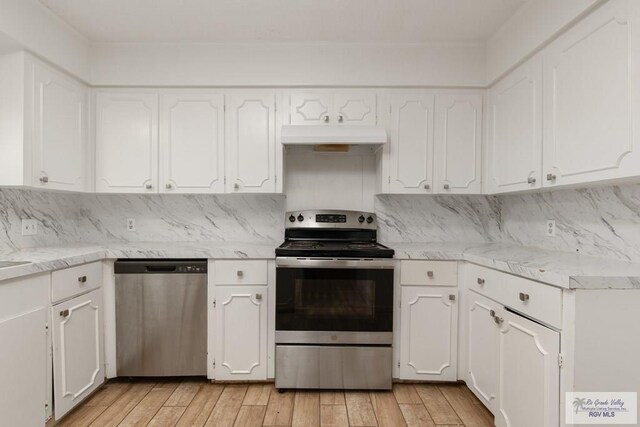 kitchen featuring white cabinets, light hardwood / wood-style floors, backsplash, and appliances with stainless steel finishes