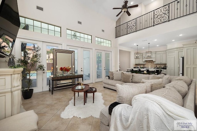 tiled living room with a wealth of natural light, french doors, high vaulted ceiling, and ceiling fan