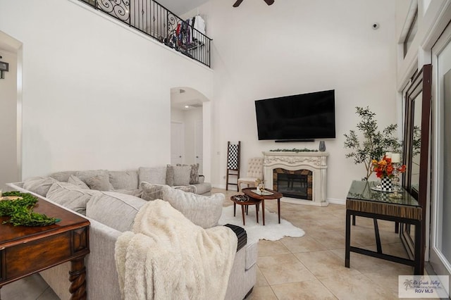 tiled living room with a towering ceiling and ceiling fan