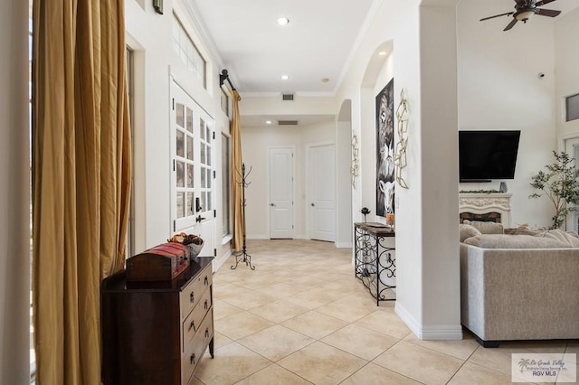 hallway with light tile patterned floors and ornamental molding