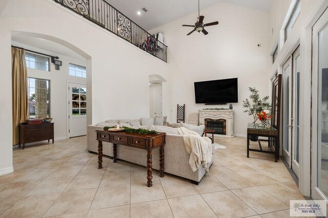 living room featuring ceiling fan, light tile patterned flooring, and high vaulted ceiling