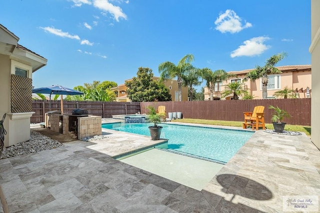 view of swimming pool featuring a patio area, an in ground hot tub, and exterior kitchen