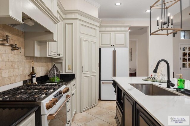 kitchen with white appliances, sink, hanging light fixtures, tasteful backsplash, and light tile patterned flooring