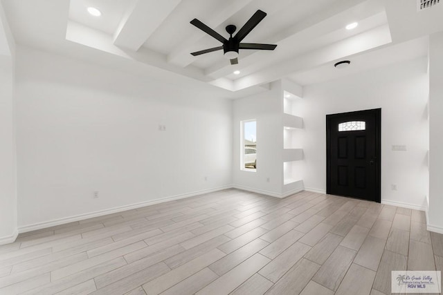 entrance foyer with ceiling fan and a raised ceiling