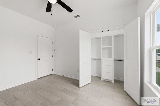 unfurnished bedroom featuring ceiling fan, light wood-type flooring, and a closet