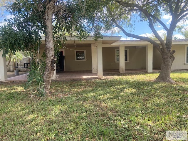 back of property featuring a yard and a patio area