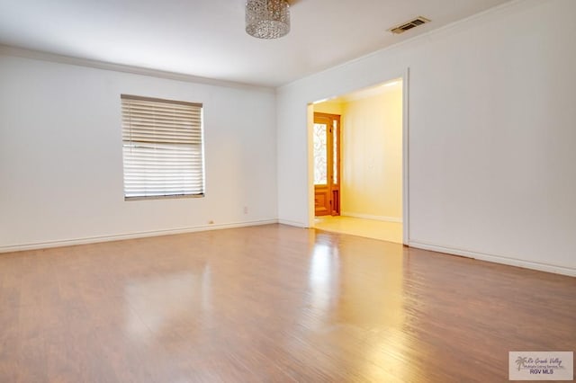 unfurnished room featuring light hardwood / wood-style floors and crown molding