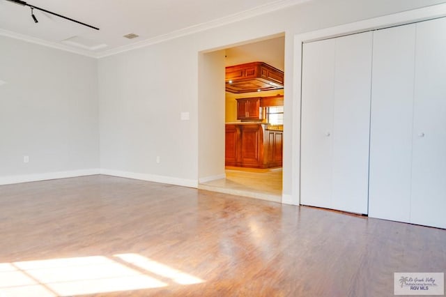 interior space featuring ornamental molding and light wood-type flooring