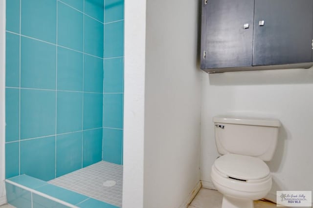 bathroom featuring a tile shower and toilet