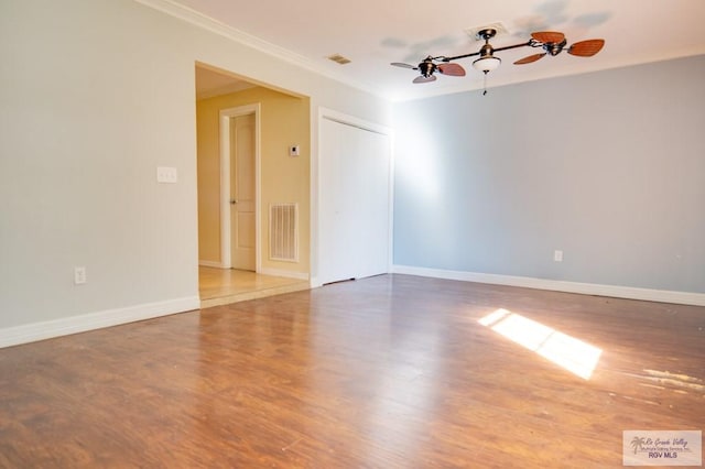 spare room featuring wood-type flooring, ceiling fan, and ornamental molding