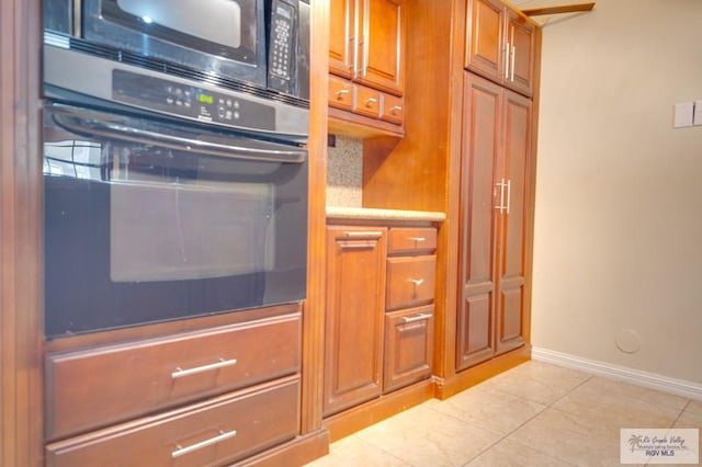 kitchen with black appliances and light tile patterned floors