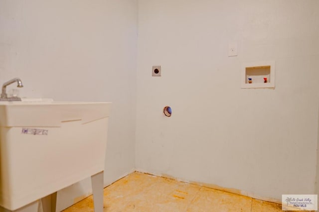 clothes washing area featuring hookup for an electric dryer, washer hookup, and sink