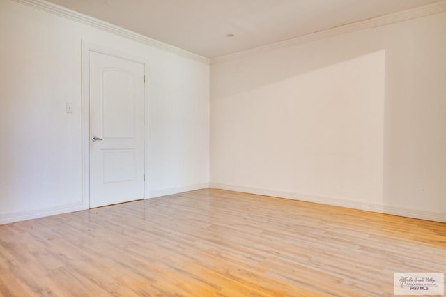 empty room featuring ornamental molding and light wood-type flooring