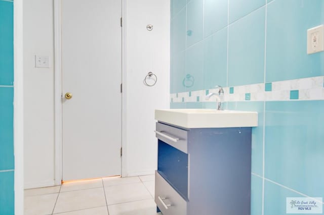 bathroom with tile patterned flooring, vanity, and tile walls