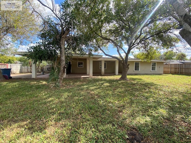 back of property featuring a patio area and a yard