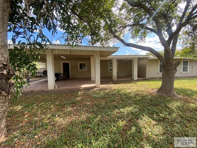 rear view of house with a yard and a patio area