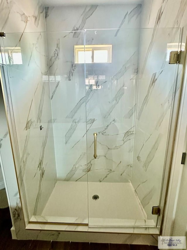 bathroom with a marble finish shower