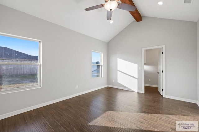 empty room featuring lofted ceiling with beams, a mountain view, a healthy amount of sunlight, and dark hardwood / wood-style floors