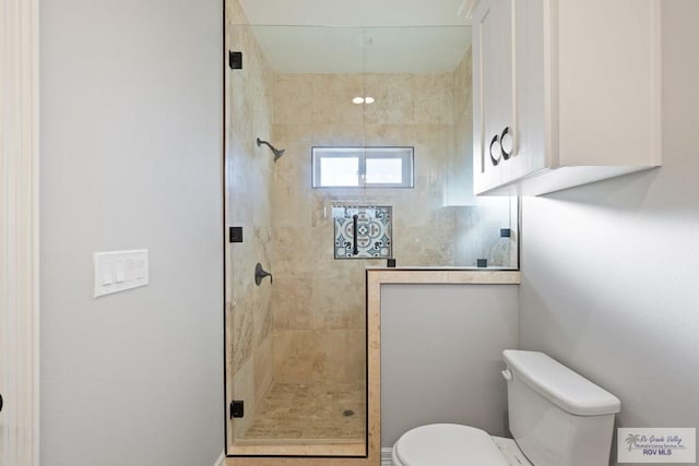 bathroom featuring toilet and a tile shower